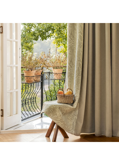 a chair sitting in front of a window with a basket of fruit on it