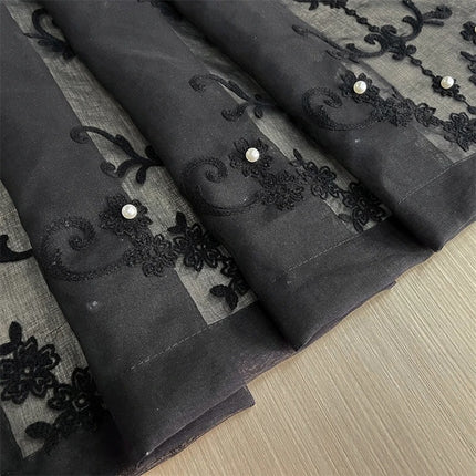 a close up of a piece of cloth with black lace on it