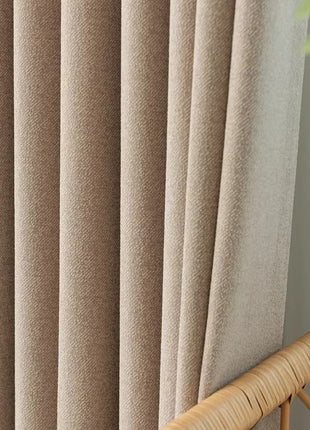 a close up of a curtain with a plant in the background