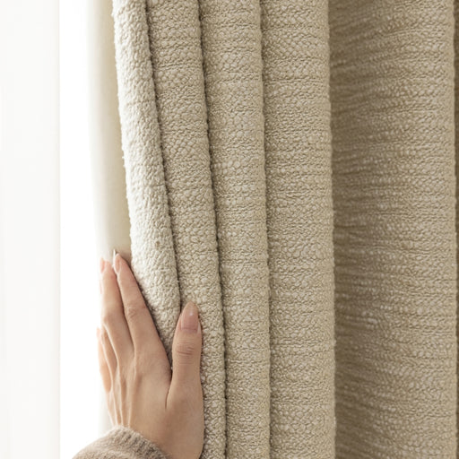 a person is holding a curtain with their hand