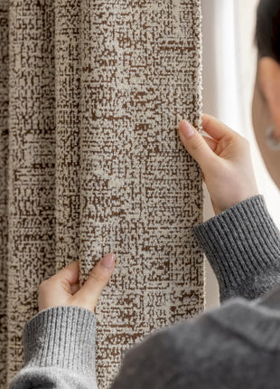 a woman is looking at a curtain in front of a window