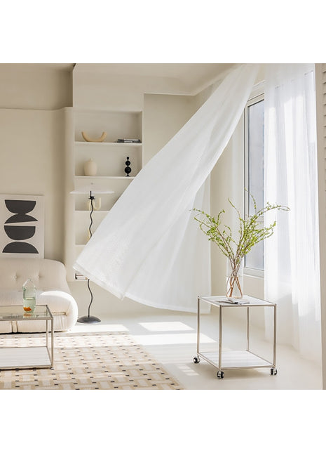 a living room with a white couch and white curtains