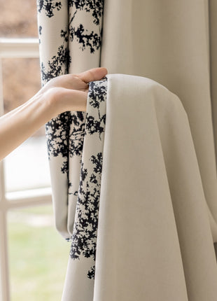 a person is opening curtains with their hand