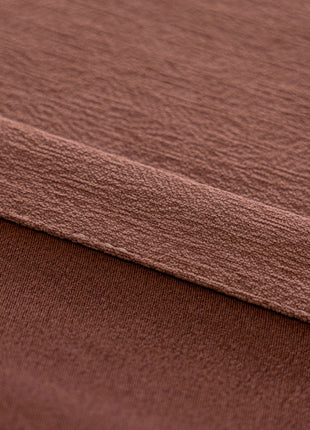 a close up of a brown blanket on a bed