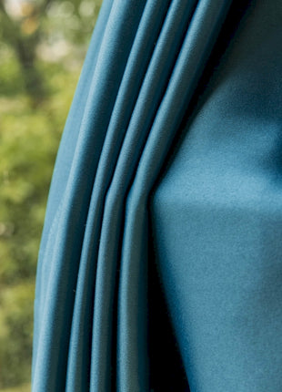 a close up of a blue curtain with trees in the background