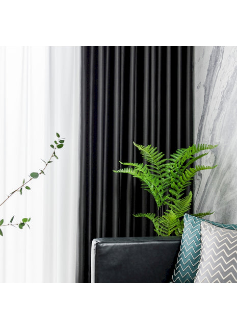 a green plant sitting on top of a black chair