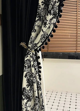a black and white curtain with pom pom trim