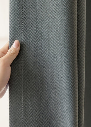 a person is holding a curtain in their hand