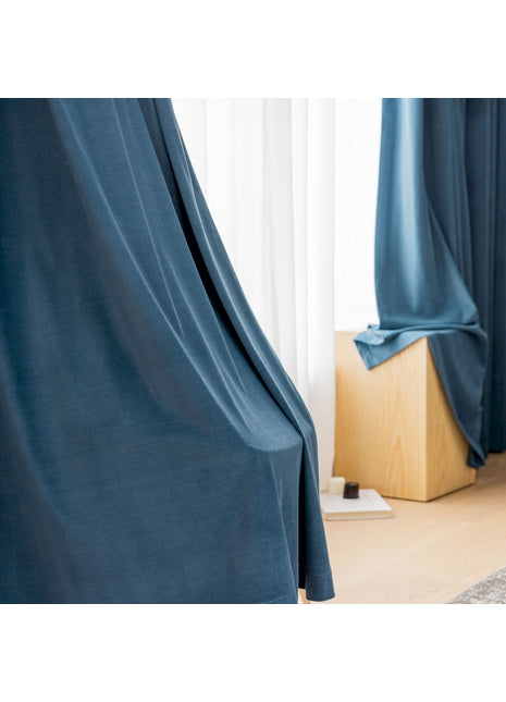 a room with a blue curtain and a wooden floor