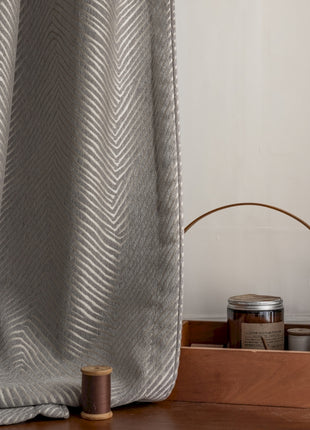 a close up of a curtain with a spool of thread next to it