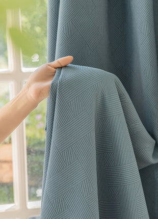 a person is holding a curtain in front of a window