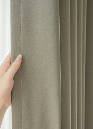 a person's hand on the curtain of a window