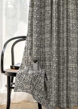 a chair sitting in front of a window next to a curtain