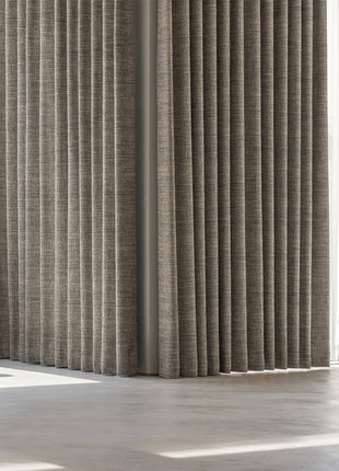 a living room with a large window covered in curtains