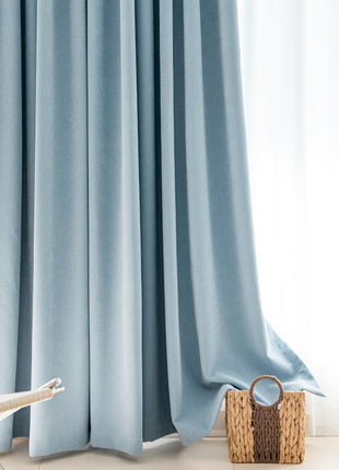 a chair sitting next to a window with a blue curtain