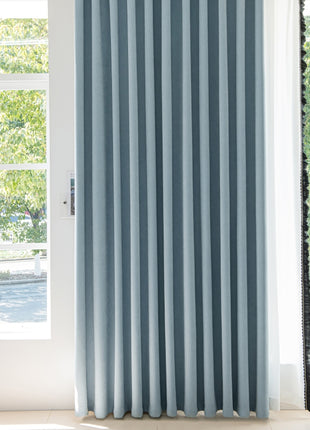 a blue curtain hanging in front of a window