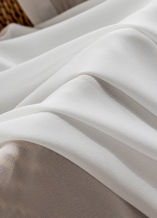 a close up of a bed with white sheets