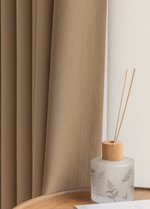 a bottle of reeds sitting on a table next to a window