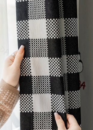 a woman holding a black and white checkered curtain