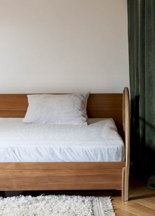 a bed sitting in a bedroom next to a window