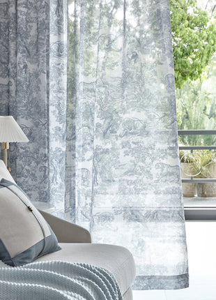 a white couch sitting next to a window covered in curtains