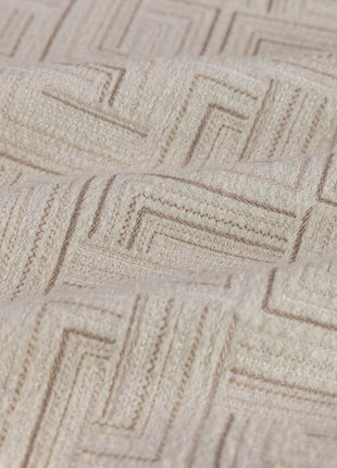 a close up view of a bed with a beige bedspread