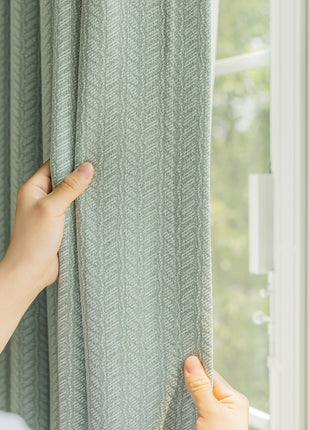a person is holding a curtain in front of a window