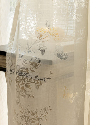 a white curtain with a floral design on it