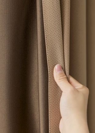 a person's hand is pulling the curtain off of a window