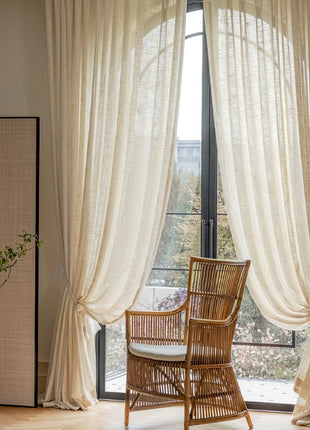 a chair sitting in front of a window next to a potted plant