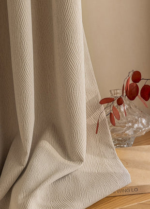 a vase of flowers sitting on a table next to a curtain