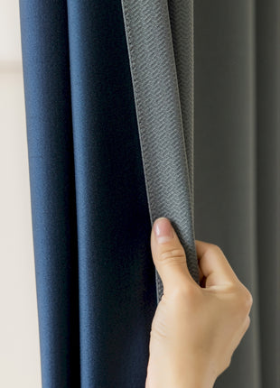 a person holding a curtain with their hand