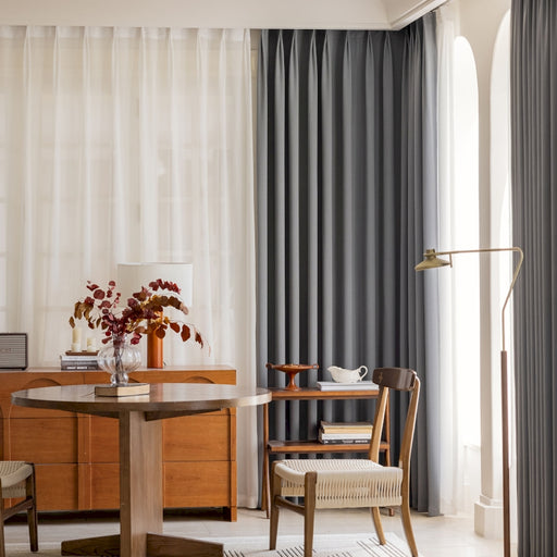 a living room with a table a chair and a window