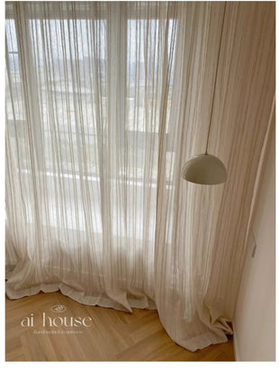 a room with a white curtain and a floor lamp