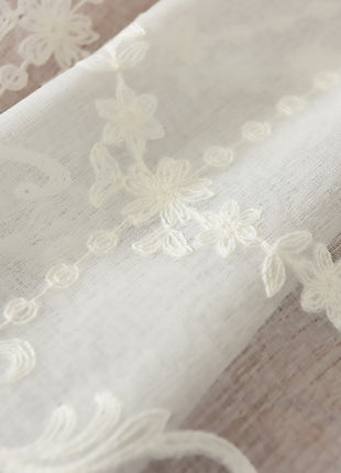 a close up of a curtain with white lace