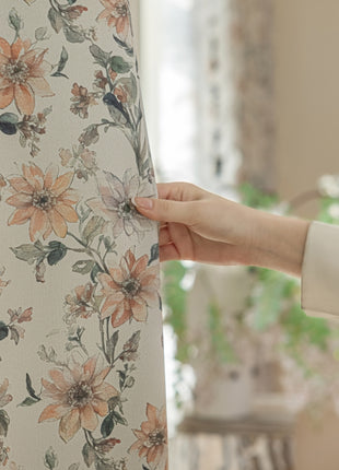 a person holding a curtain with a flower pattern on it