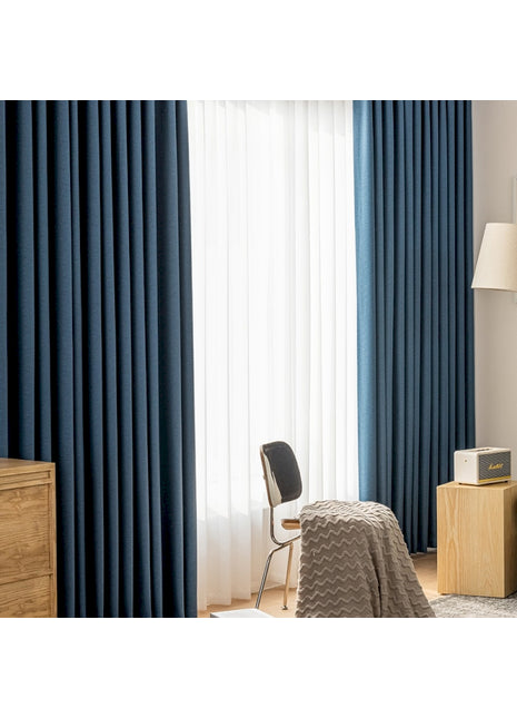 a bedroom with blue curtains and a bed