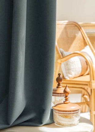 a room with a chair and a table with a vase on it