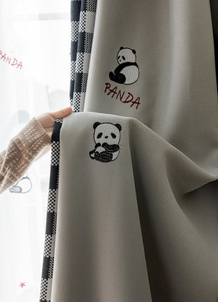 a person holding onto a curtain with panda embroidered on it
