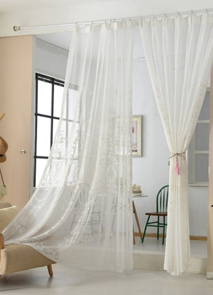 a living room with a chair and a white curtain
