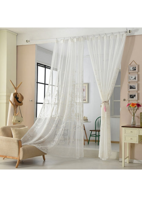 a living room with a chair and a white curtain