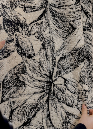 a person holding a piece of fabric in front of a window