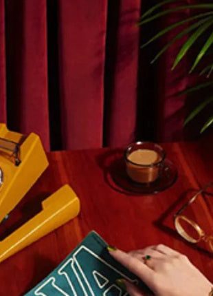 a person sitting at a table with a book and a phone