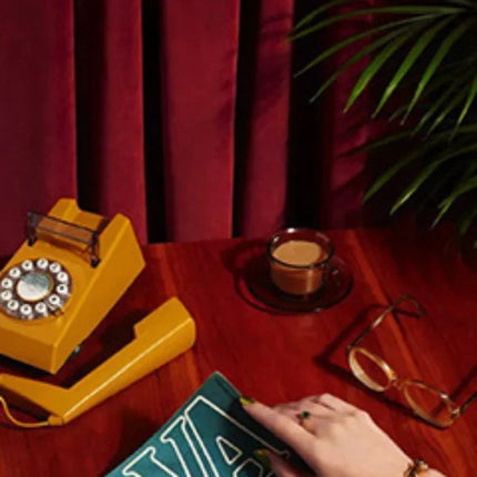 a person sitting at a table with a book and a phone