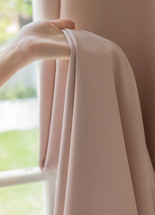 a person's hand holding a curtain in front of a window