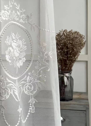 a white curtain with a floral design on it