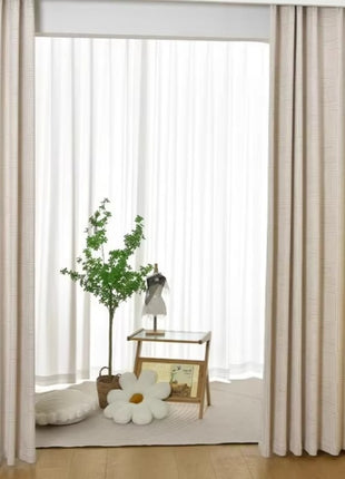 a living room with white curtains and a white chair