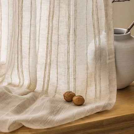 a white curtain with two nuts on a wooden table