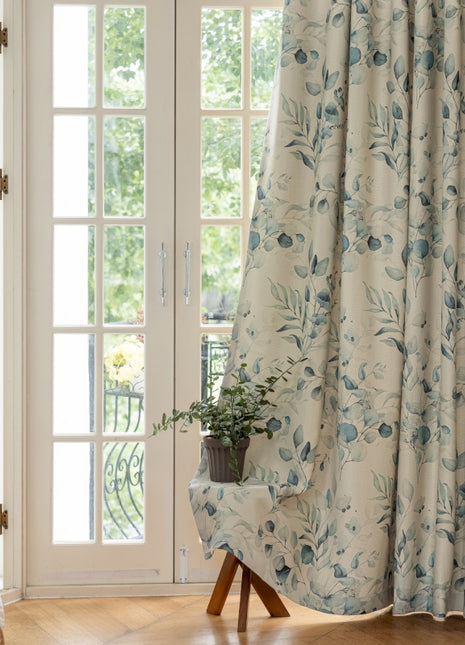 a chair sitting in front of a window covered in curtains