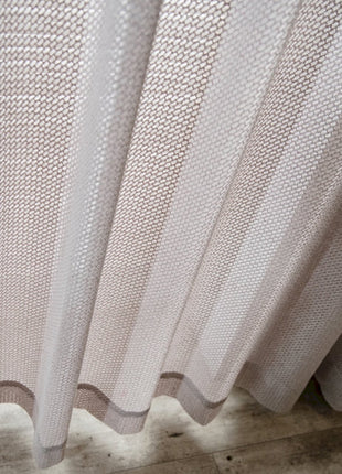 a close up of a white curtain on a wooden floor